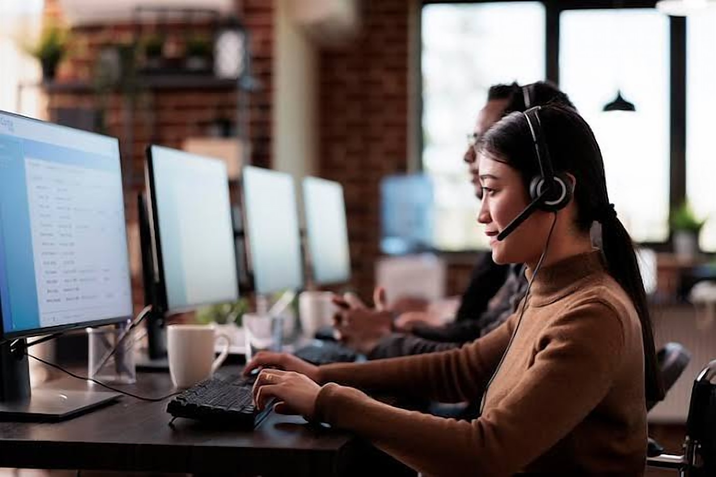 Operator wearing a headset at a monitoring desk